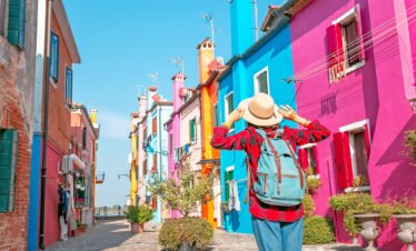 Traveler on the colourful Burano island near Venice, Italy